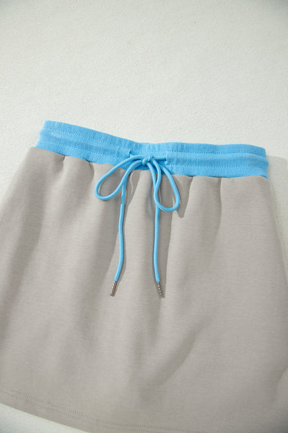 Ensemble 2 pièces jupe-short mini à cordon, veste zippée sport vert fumée à bord contrastant